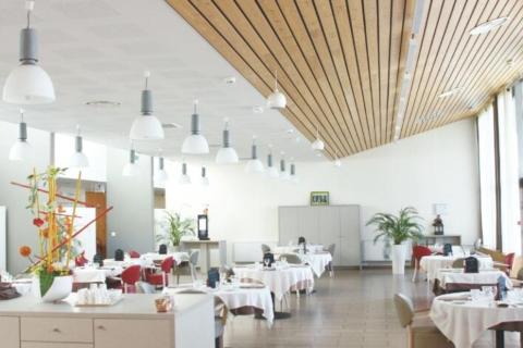 Restaurant, plafond en lames de bois et lumière naturelle
